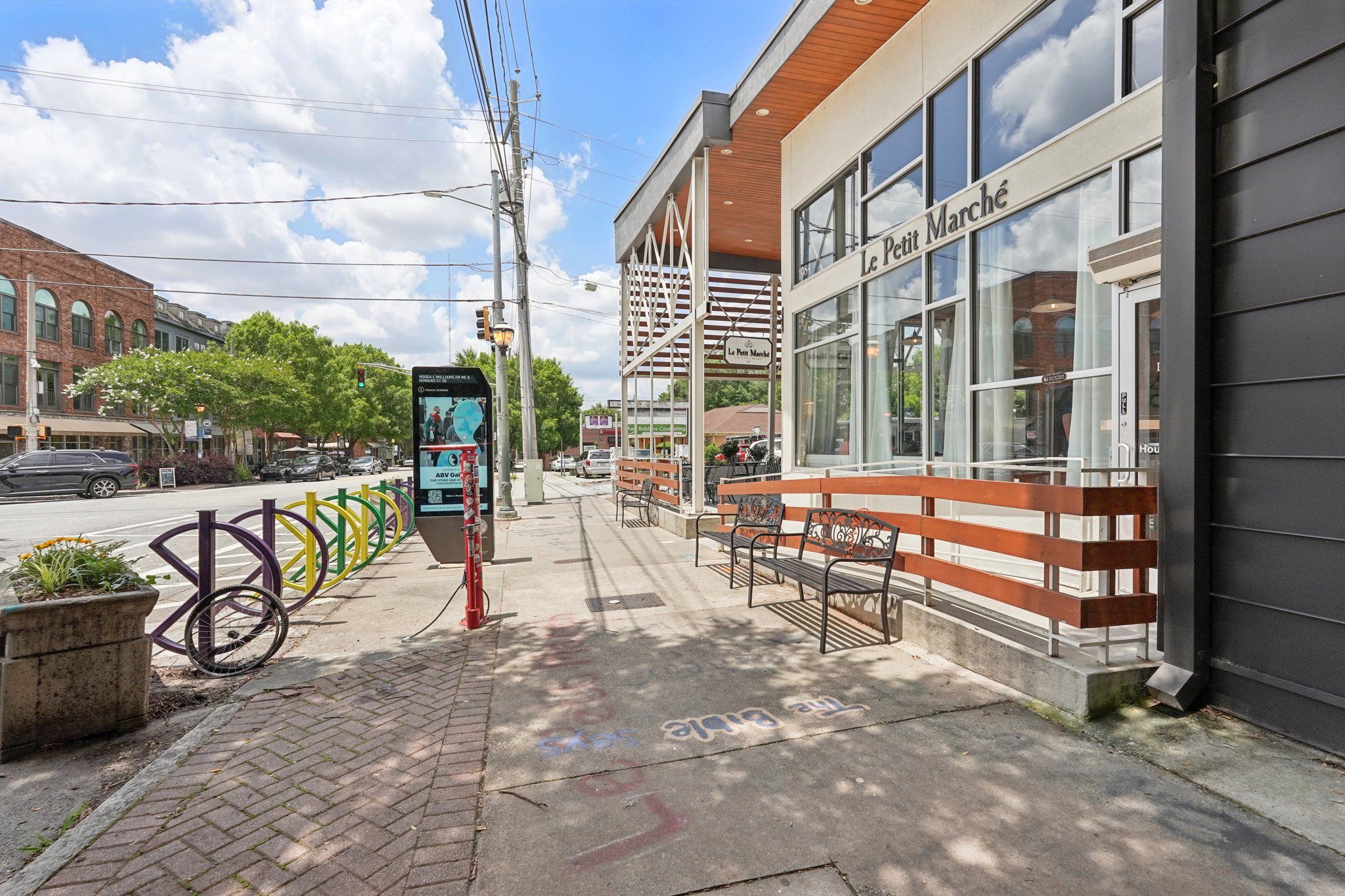 Le Petit Marché restaurant:  a street view with a bench, a bike rack